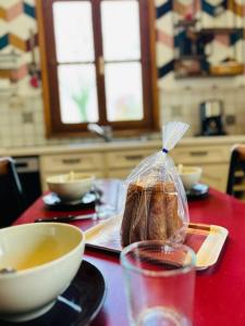 a table with a bag of bread and a bowl of soup at Le Gîte d'en Bas in Quesnoy-le-Montant