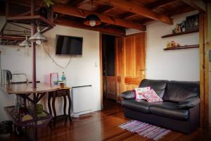a living room with a leather couch and a table at Loft Antiguo sobre Av de Mayo in Buenos Aires