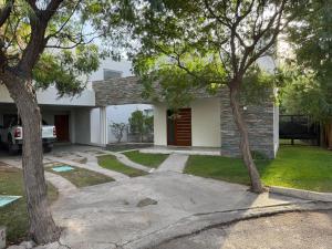 una casa con entrada y dos árboles en Mendoza Casa Barrio Cerrado en Chacras de Coria