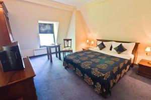 a hotel room with a bed and a desk at Vila Royal in Bacău