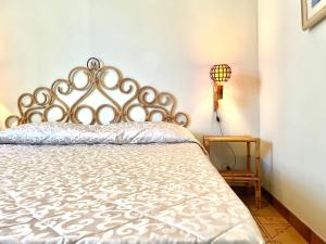 een slaapkamer met een bed met een metalen hoofdeinde bij Villa Marina con piscina sul mare in Platamona