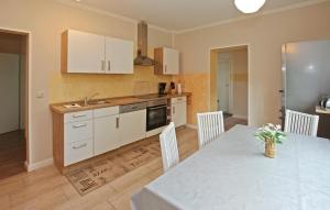 a kitchen with a table and white cabinets at 2 Bedroom Stunning Apartment In Burg Stargard in Burg Stargard