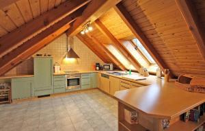 a large kitchen with blue cabinets in an attic at Nice Apartment In Waren mritz With Wifi in Waren