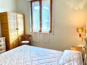 een slaapkamer met een bed en een raam bij Villa Marina con piscina sul mare in Platamona