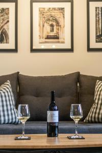 a bottle of wine sitting on a table with two glasses at Alba Spacious Maisonette in Corfu