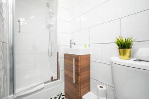 a white bathroom with a toilet and a shower at Wolverhampton 1 Bed Apartment - Top Rated -Netflix - Wifi - 12AC in Wolverhampton