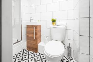 een witte badkamer met een toilet en een douche bij Wolverhampton 1 Bed Apartment - Top Rated -Netflix - Wifi - 12AC in Wolverhampton