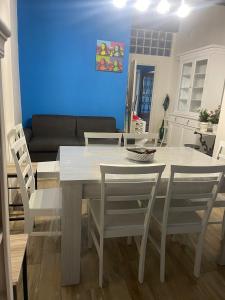 een eetkamer met een witte tafel en stoelen bij Casa il Tramonto del Cilento in Scario