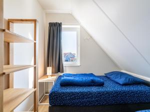 een slaapkamer met een blauw bed en een raam bij Nice holiday home in Simonshaven with garden in Simonshaven