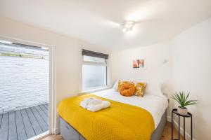 Un dormitorio con una cama con calabazas. en Charming 1 Bedroom Flat with Private Patio - West London, Kensington, Earl's Court, Chelsea en Londres