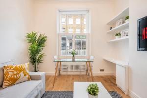 a living room with a table and a window at Charming 1 Bedroom Flat with Private Patio - West London, Kensington, Earl's Court, Chelsea in London