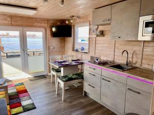 a kitchen with a counter and a table with chairs at Hausboot Lilla Lina in Fehmarn