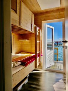 a bed in a wooden room with a open door at Hausboot Lilla Lina in Fehmarn