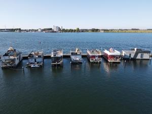 a group of boats docked at a dock in the water at Hausboot Lilla Lina in Fehmarn