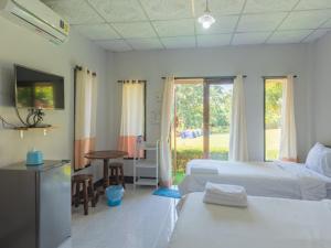 a bedroom with two beds and a table and a television at Bansuan viewpai in Pai