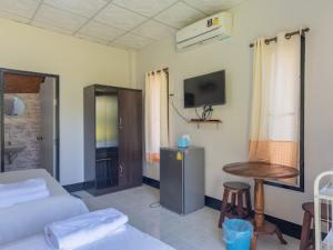 ein Wohnzimmer mit einem Sofa, einem Tisch und einem TV in der Unterkunft Bansuan viewpai in Pai