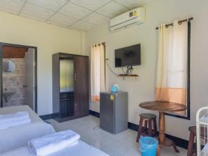 a living room with a couch and a table and a tv at Bansuan viewpai in Pai