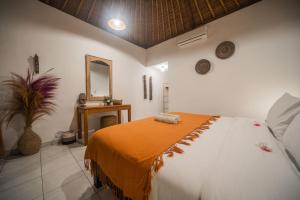 a bedroom with a large bed and a mirror at Olo Surf Nature in Uluwatu