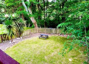 a park bench sitting in the grass near a fence at Chapel Barn in Bodmin