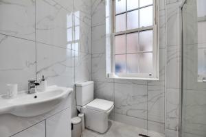 a white bathroom with a sink and a toilet at Lovely 1-Bed Apartment in Wigan in Wigan