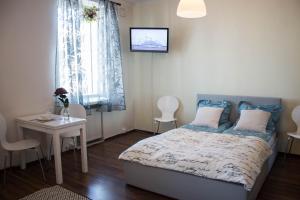 um quarto com uma cama, uma mesa e uma janela em Orchid&Sakura studios Kamppi em Helsinque