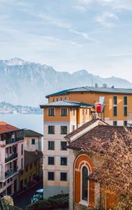 a group of buildings with mountains in the background at Authentic Italian Home in Griante Cadenabbia