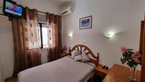 a small bedroom with a bed and a television at Santa Isabel in Portimão