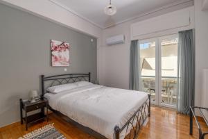 a bedroom with a bed and a large window at Marina Zeas Livemodern in Piraeus