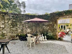 a patio with a table and chairs and an umbrella at Chapel Annex in Bodmin