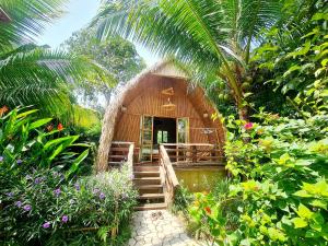una pequeña casa con una escalera que conduce a ella en Bamboo Eco Village en Can Tho