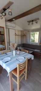 a dining room with a blue table and chairs at Mobil home 6 personnes confort Océan climatisé camping avec piscine Agde in Agde