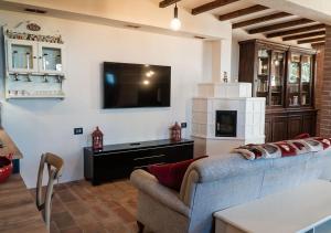 a living room with a couch and a tv at Casale Gambini in Quattro Castella