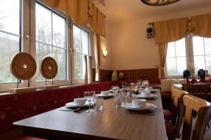 - une grande table en bois dans un restaurant avec fenêtres dans l'établissement Groepshuis Waldfrieden, à Medebach