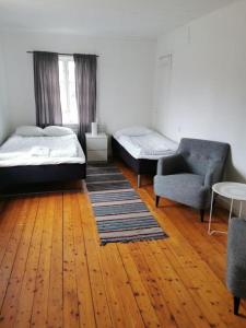 um quarto com 2 camas, um sofá e uma cadeira em Västervik rum & Stugor em Västervik