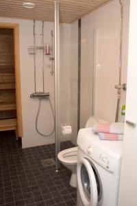 a bathroom with a shower and a washing machine at Deluxe Apartment with Lake View and Sauna, Lahti in Lahti