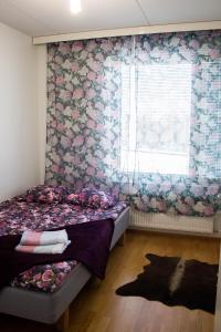 a bedroom with a bed and a window with flowers at Deluxe Apartment with Lake View and Sauna, Lahti in Lahti