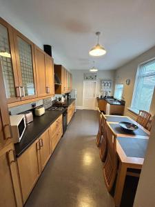 a large kitchen with wooden cabinets and a large island at Huge 5 bed on the edge of Shildon in New Shildon