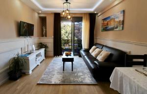 a living room with a black couch and a table at Central Park Apartment in Tivat