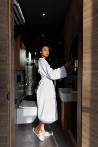 a woman standing in a bathroom with a sink at Hotel 28 in Bishkek