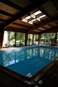 a large swimming pool with a ceiling and windows at Les INSOLITES DE LA TOUCHE in Azay-le-Rideau