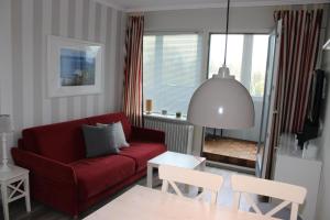 a living room with a red couch and a table at Ferienwohnung Ostseeperle S152 in Brasilien