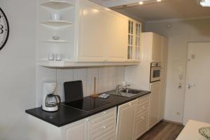 a kitchen with white cabinets and a black counter top at Ferienwohnung Ostseeperle S152 in Brasilien