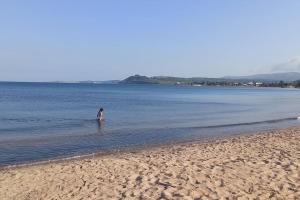 a person standing in the water at the beach at The poet's house in Longá
