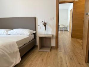 Un dormitorio con una cama y una mesa con un jarrón. en Bernina Suite 2 - vicino al Bernina Express en Tirano