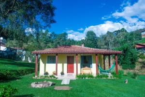 a small house with a swing in a yard at Chalés Cachoeira do Vale in Camanducaia