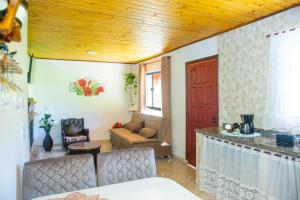 a living room with a couch and a table at Chalés Cachoeira do Vale in Camanducaia