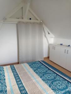 Zimmer im Dachgeschoss mit einem Bett und weißen Schränken in der Unterkunft maison de campagne au calme, Le Lude in Le Lude