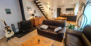 a living room with a couch and a wood stove at La Grange in Bretteville