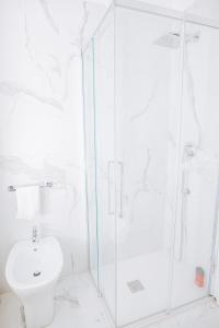 y baño blanco con ducha y aseo. en Authentic Italian Home, en Cadenabbia