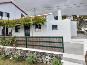 Casa da Avó Couta في أنغرا دو إِراويزو: منزل أبيض مع سور خشبي